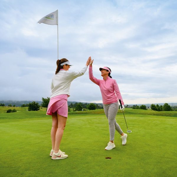 zwei Golferinnen klatschen ein